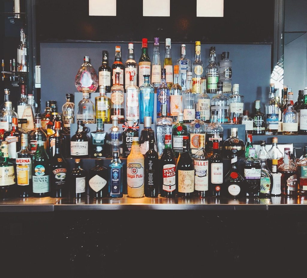 A wide selection of liquor bottles displayed on a bar shelf