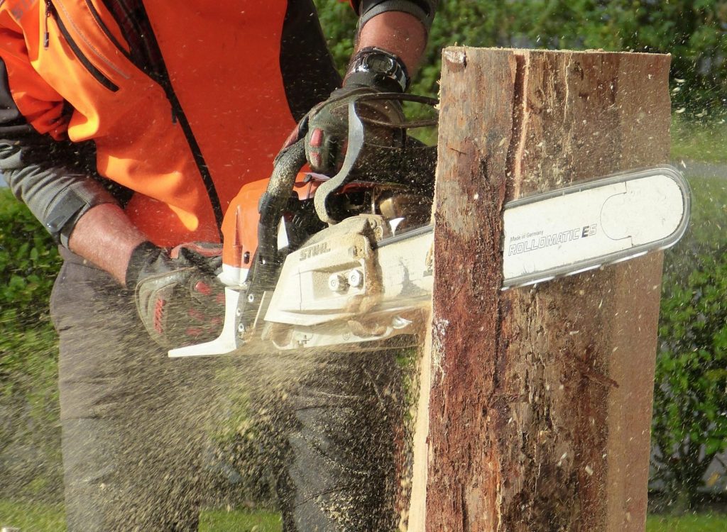 worker-cutting-wood-with-chainsaw-outdoor