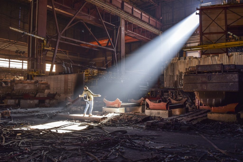 Person standing inside an abandoned industrial factory