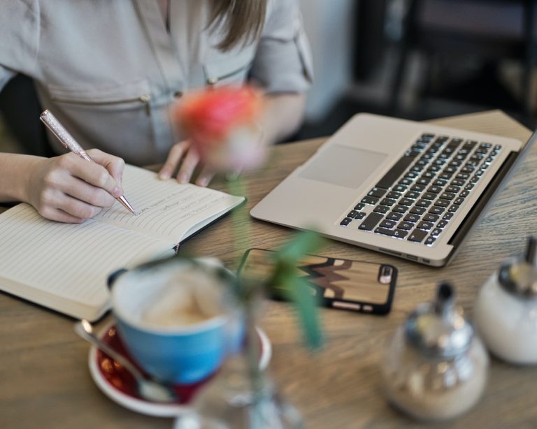 Woman writing down goals to reach full potential